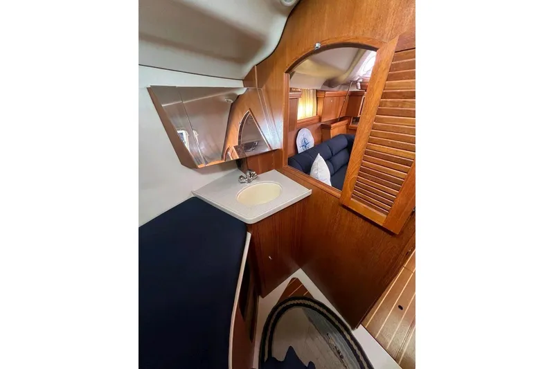 Slide: The Image of Interior of 2003 Hunter 386 yacht with wooden finish and compact sink area. - 19