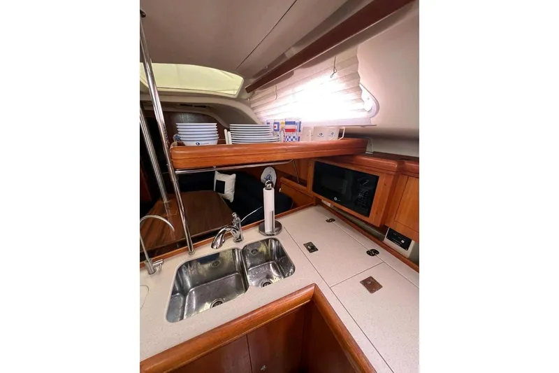 Slide: The Image of Interior of 2003 Hunter 386 yacht kitchen with sink, microwave, and wooden cabinetry. - 20