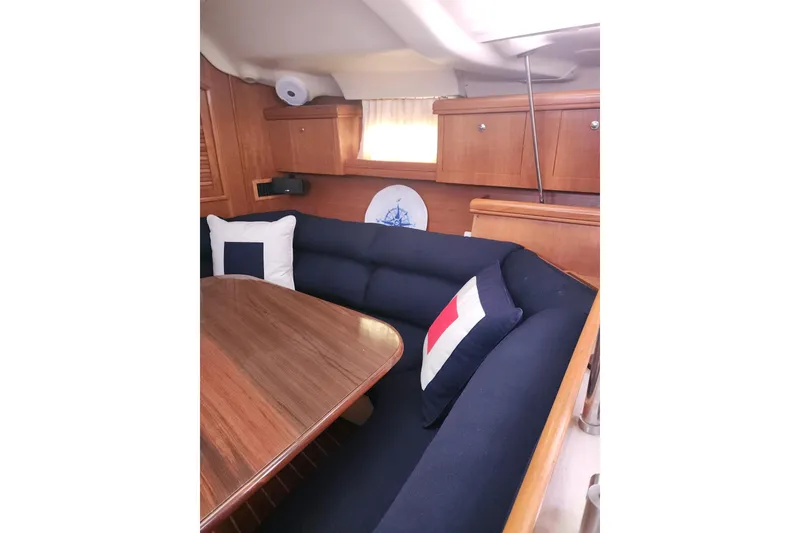 Slide: The Image of Interior of 2003 Hunter 386 sailboat with wooden table and navy seating. - 24