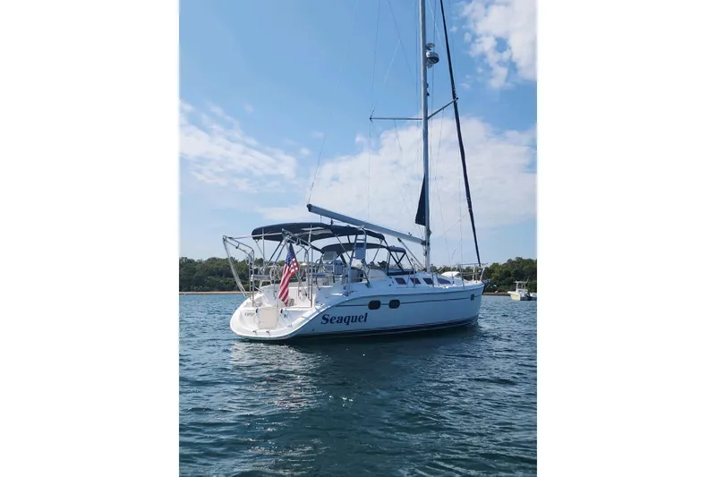 Slide: The Image of 2003 Hunter 386 sailboat named "Seaquel" on calm water under blue sky. - 4