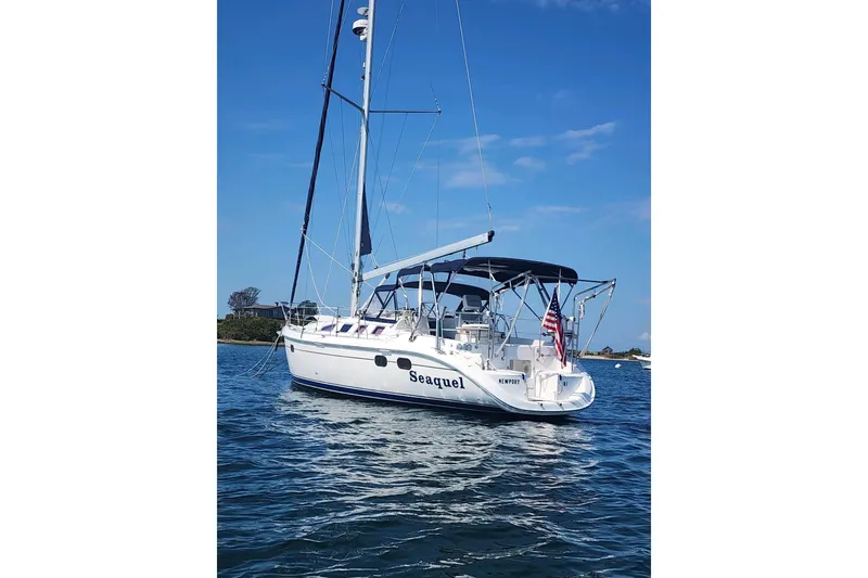 Slide: The Image of 2003 Hunter 386 sailboat named "Seaquel" on calm water under clear blue sky. - 6