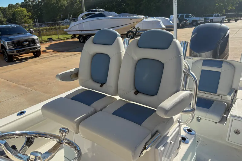 Slide: The Image of 2019 Ranger 2510 Bay boat with dual cushioned seats and steering wheel in a marina setting. - 8