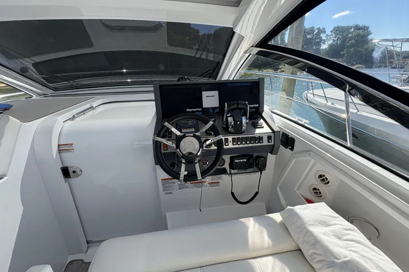 Slide: The Image of 2021 Cruisers Yachts 390 Express Coupe helm with modern navigation equipment and comfortable seating. - 6