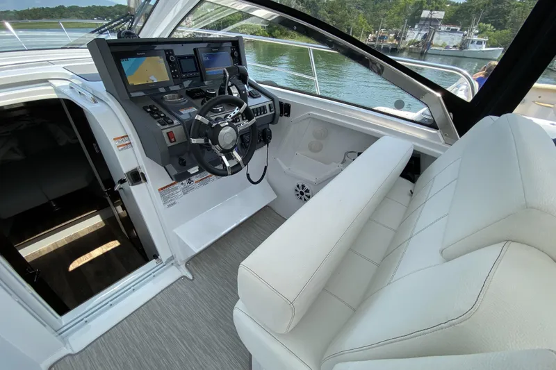 Slide: The Image of 2021 Cruisers Yachts 390 Express Coupe helm with modern navigation displays and plush seating. - 7
