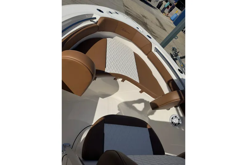 Slide: The Image of 2026 Pioneer 202 Islander boat interior with brown and white seating, docked outdoors. - 10