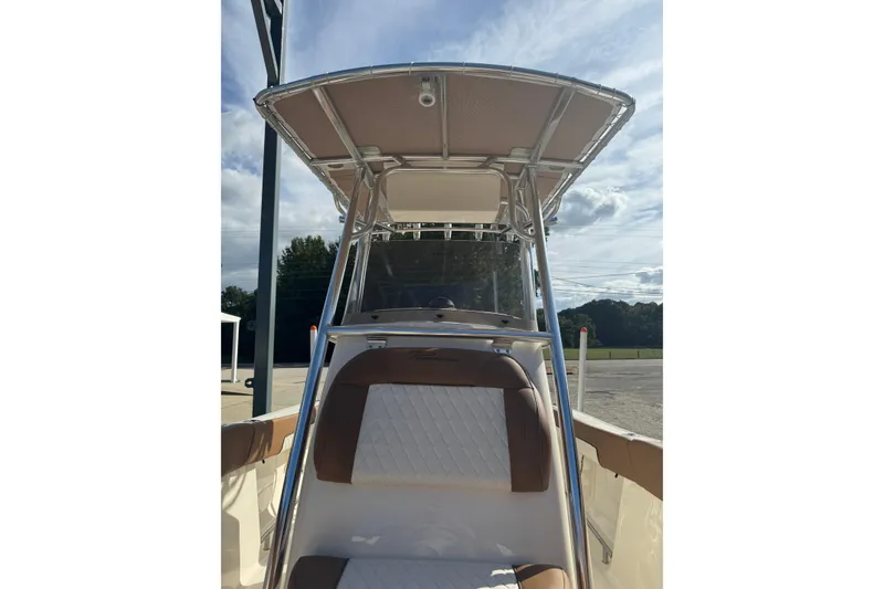 Slide: The Image of 2026 Pioneer 202 Islander boat with T-top and cushioned seating, under a clear sky. - 11