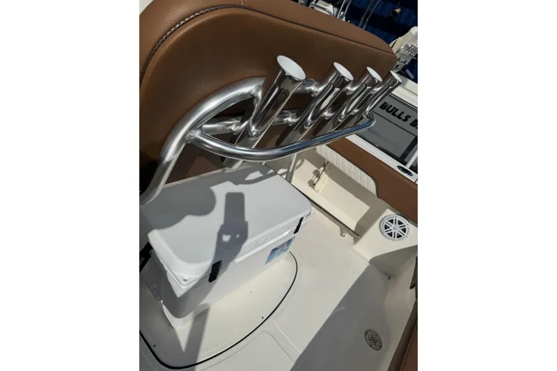 Slide: The Image of 2026 Pioneer 202 Islander boat interior with rod holders and cooler. - 4