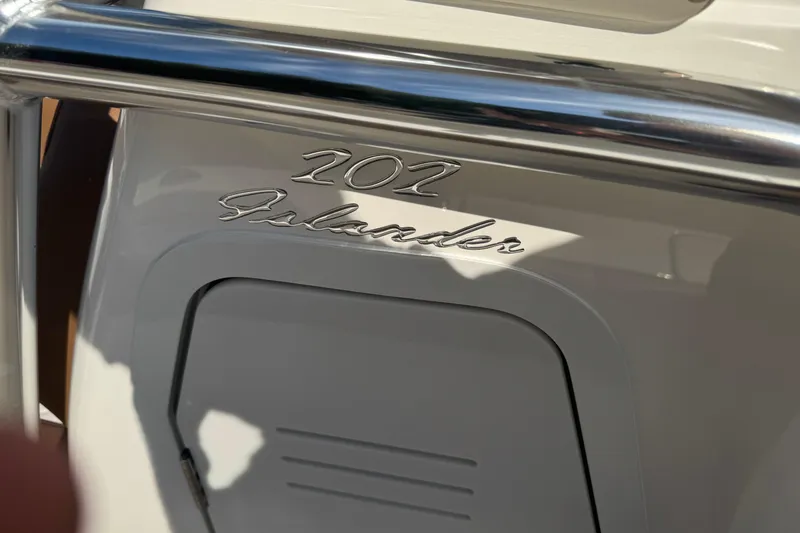 Slide: The Image of 2026 Pioneer 202 Islander boat emblem with chrome detailing. - 9