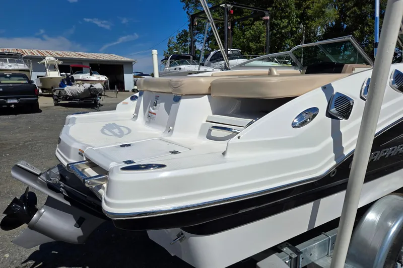 Slide: The Image of 2012 Chaparral 196 SSi boat with sleek design, parked outdoors under clear blue sky. - 13