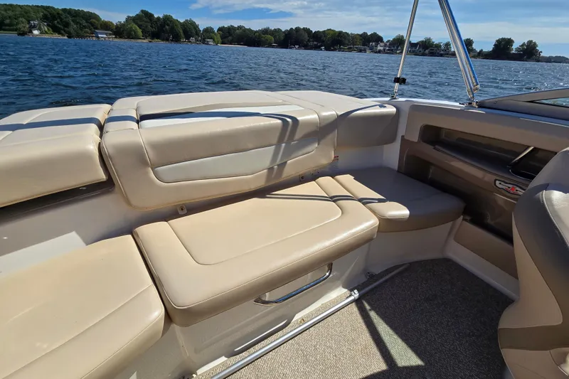 Slide: The Image of 2012 Chaparral 196 SSi boat interior with beige seating, on a sunny lake. - 23