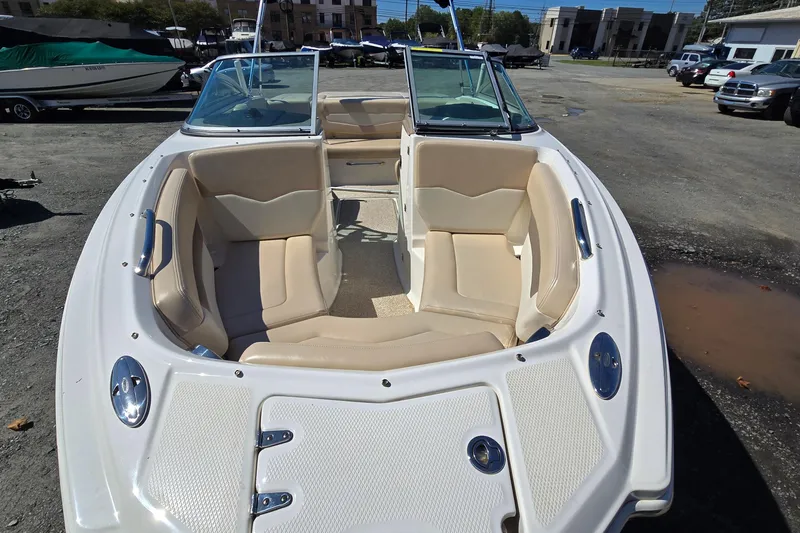 Slide: The Image of 2012 Chaparral 196 SSi boat with beige seating, parked outdoors. - 27