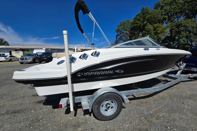 Slide: The Image of Chaparral 196 SSi 2012 boat on trailer, parked outdoors under clear blue sky. - 3