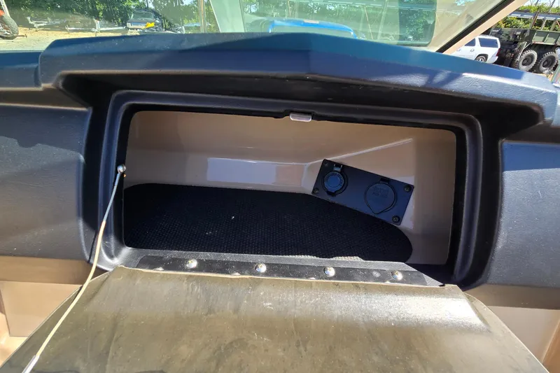 Slide: The Image of Open glove compartment in 2012 Chaparral 196 SSi boat, showing interior storage space. - 50