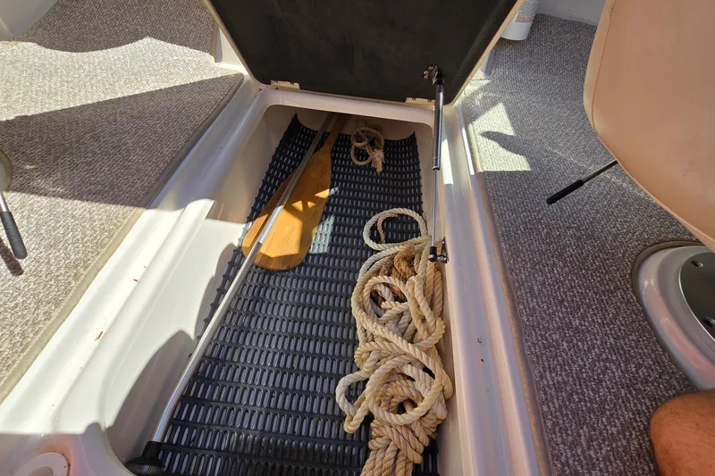 Slide: The Image of Storage compartment in 2012 Chaparral 196 SSi boat with rope and paddle. - 51