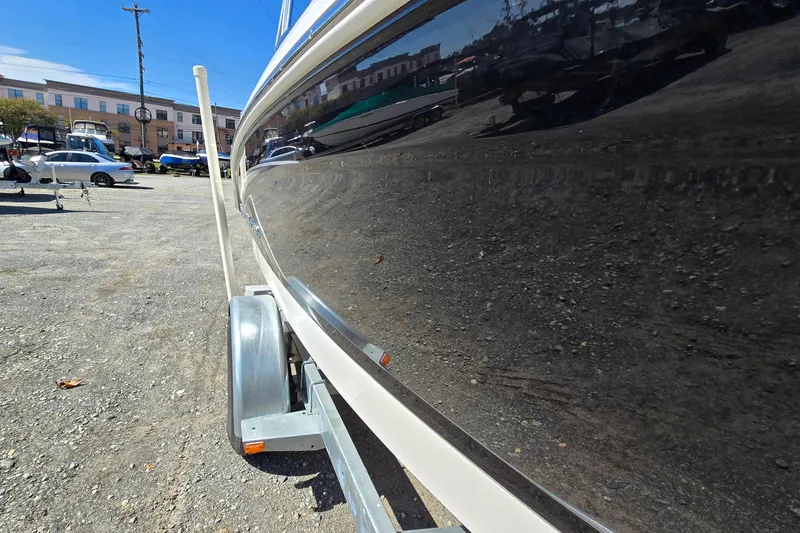 Slide: The Image of 2012 Chaparral 196 SSi boat on trailer, reflecting surroundings in a parking lot. - 9