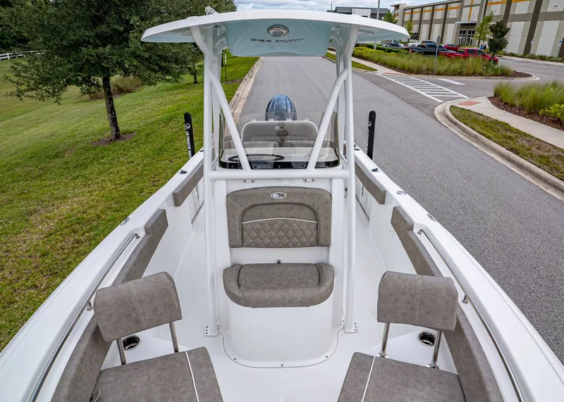 Slide: The Image of 2026 Sea Hunt Ultra 229 boat interior with cushioned seating and T-top on a road. - 19