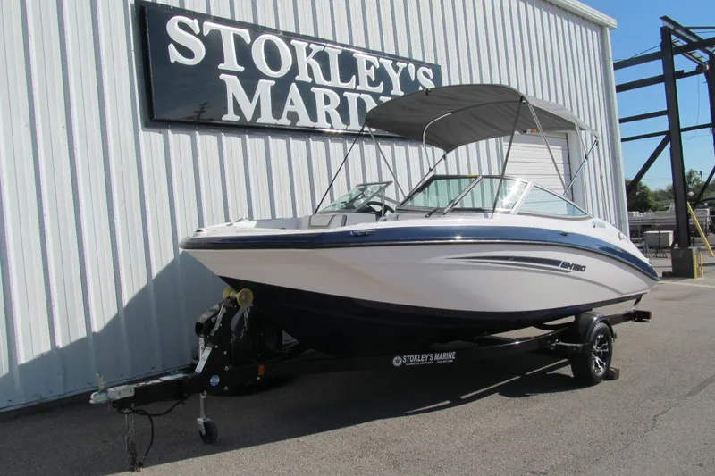 Slide: The Image of 2017 Yamaha Boats SX190 with canopy, parked outside a marine facility. - 2
