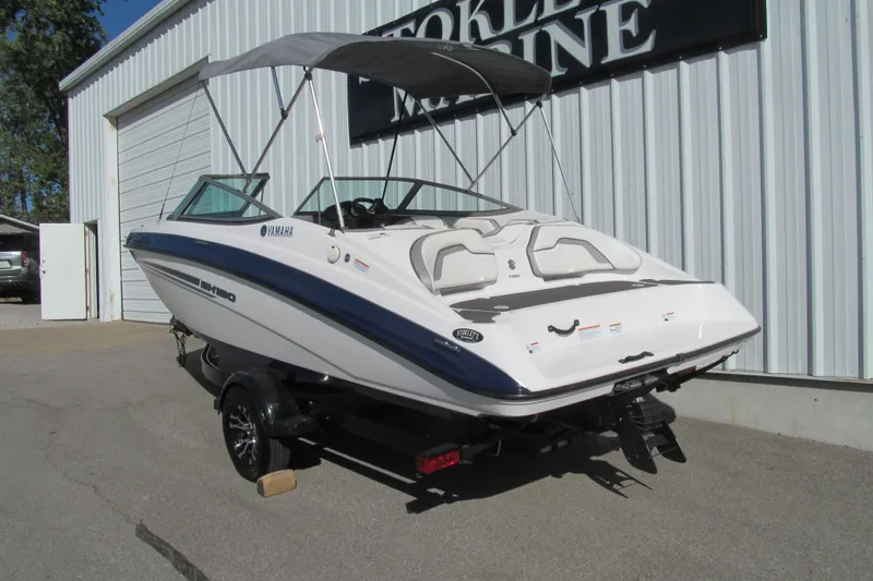 Slide: The Image of 2017 Yamaha Boats SX190, rear view, parked at a marina with canopy. - 3