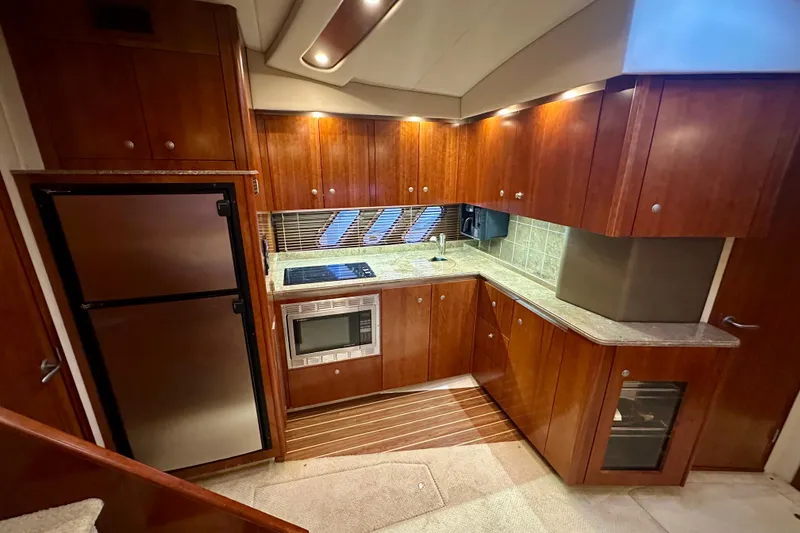 Slide: The Image of Luxurious 2009 Cruisers Yachts 460 Express kitchen with wood cabinetry and modern appliances. - 15