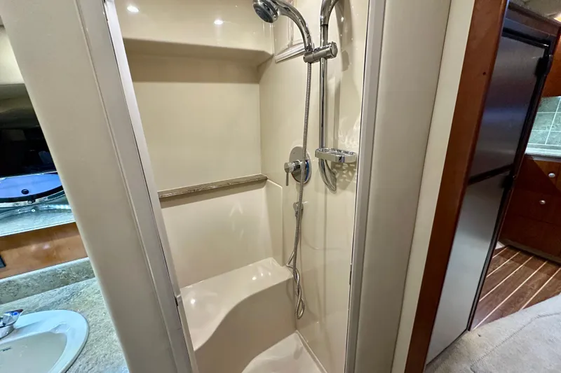Slide: The Image of 2009 Cruisers Yachts 460 Express bathroom with shower, sink, and wooden cabinetry. - 26