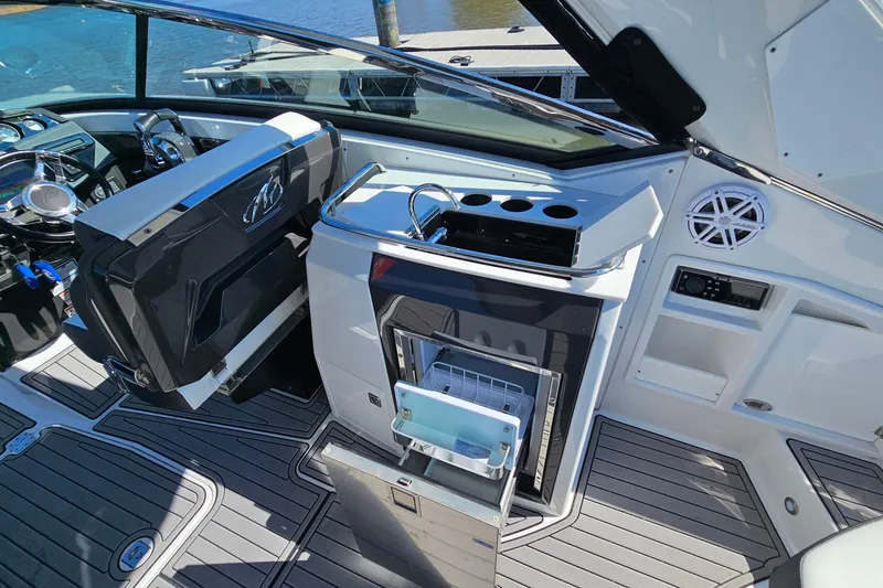Slide: The Image of 2019 Monterey 305SS Super Sport boat interior with helm, seating, and open storage compartments. - 15