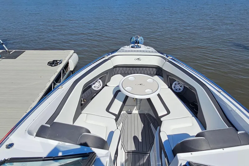 Slide: The Image of 2019 Monterey 305SS Super Sport boat interior with seating and table, docked by the water. - 27