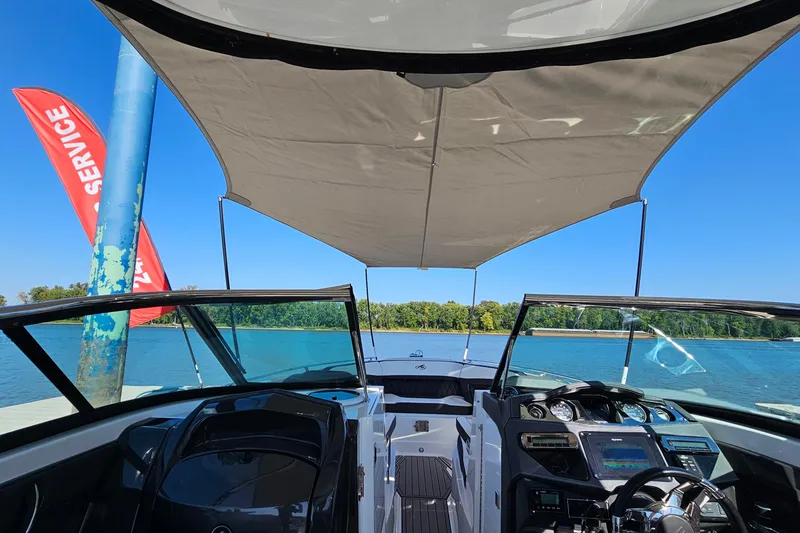 Slide: The Image of 2019 Monterey 305SS Super Sport boat interior with canopy, docked by a lake. - 32