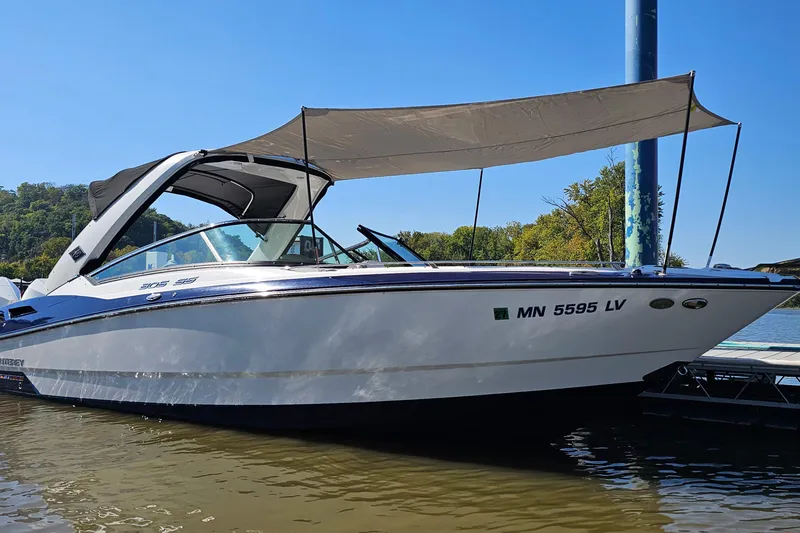 Slide: The Image of 2019 Monterey 305SS Super Sport boat docked with canopy, clear blue sky background. - 33