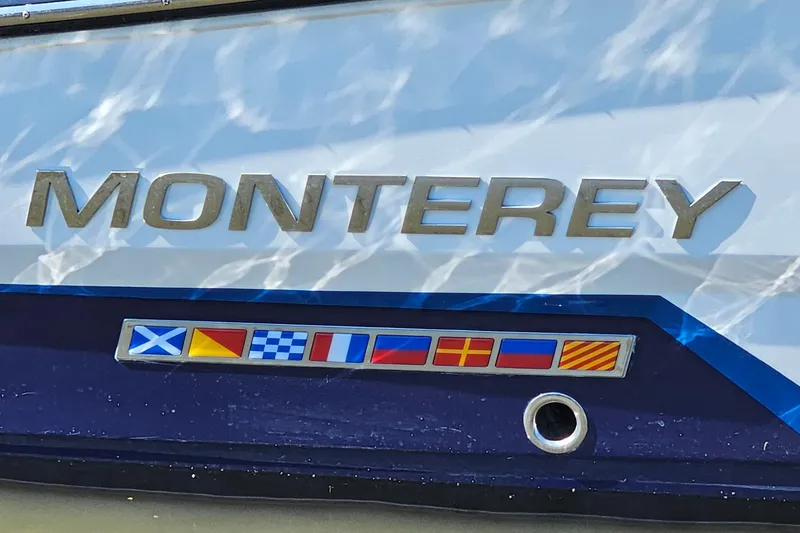 Slide: The Image of 2019 Monterey 305SS Super Sport boat with nautical flags and logo. - 40