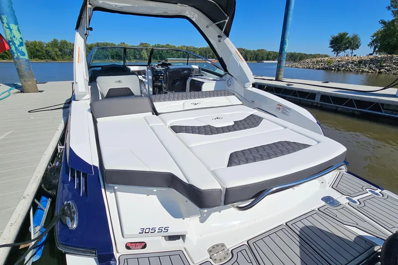 Slide: The Image of 2019 Monterey 305SS Super Sport boat docked, featuring sleek design and comfortable seating. - 8