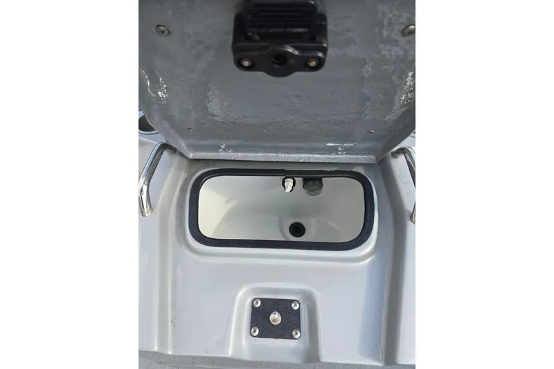 Slide: The Image of 2024 Xpress H22B Bay boat storage compartment with open lid, showcasing interior details. - 10