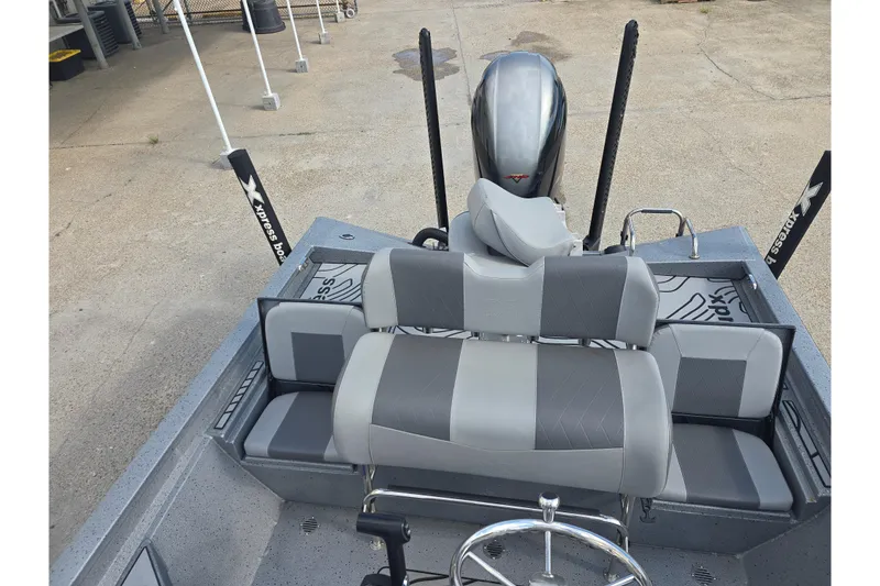 Slide: The Image of 2024 Xpress H22B Bay boat interior with gray seating and steering wheel. - 14
