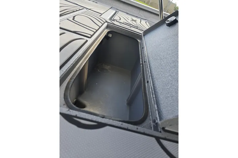 Slide: The Image of 2024 Xpress H22B Bay boat storage compartment with open lid, showcasing interior space. - 16