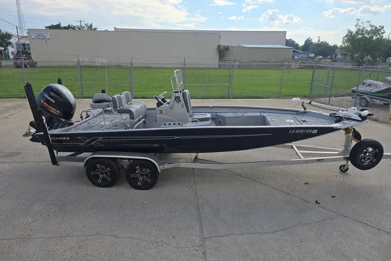 Slide: The Image of 2024 Xpress H22B Bay boat on trailer, parked outdoors, side view. - 5