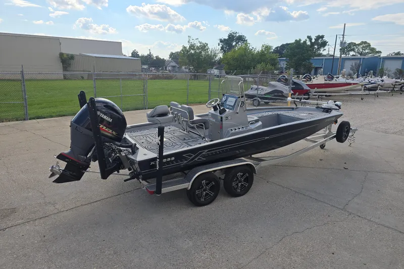 Slide: The Image of 2024 Xpress H22B Bay boat on trailer, featuring Yamaha outboard motor, parked outdoors. - 6