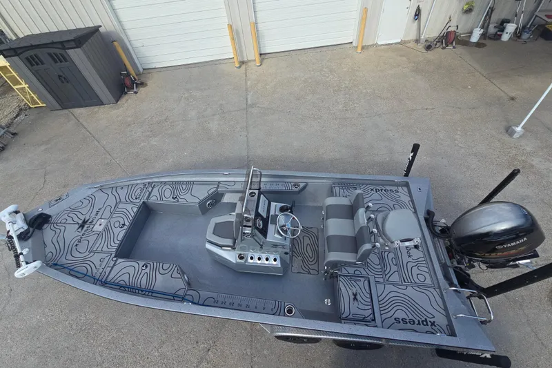 Slide: The Image of 2024 Xpress H22B Bay boat with Yamaha motor, top view in a garage setting. - 8