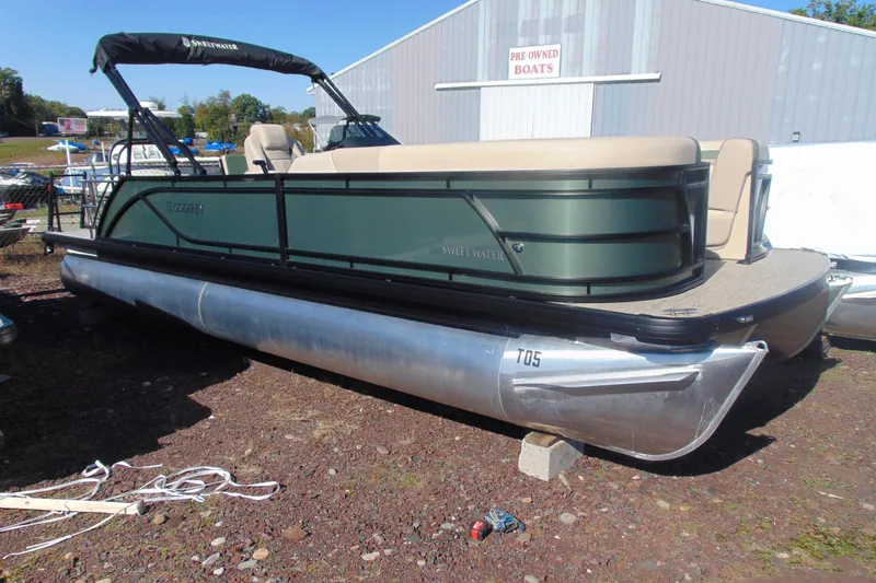 The Image of 2026 Godfrey SWEETWATER 2286 SFL pontoon boat displayed outdoors near pre-owned boats. - 1