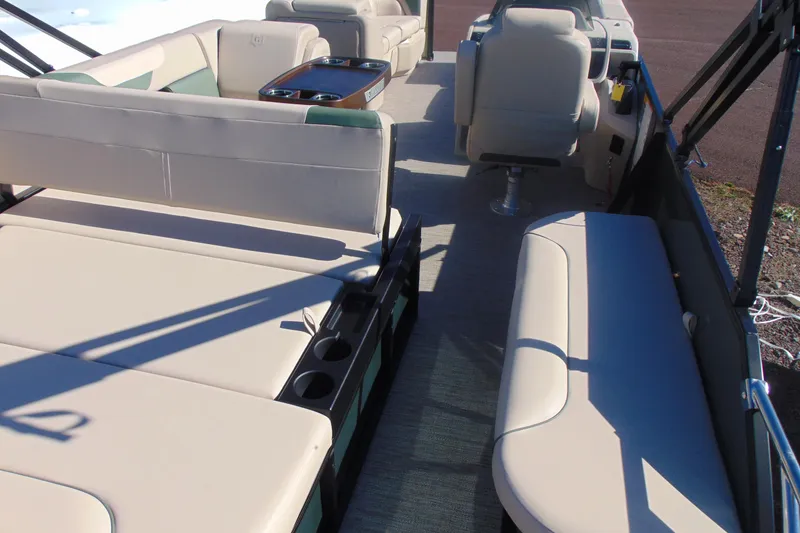 Slide: The Image of 2026 Godfrey SWEETWATER 2286 SFL pontoon boat interior with beige seating and cup holders. - 19