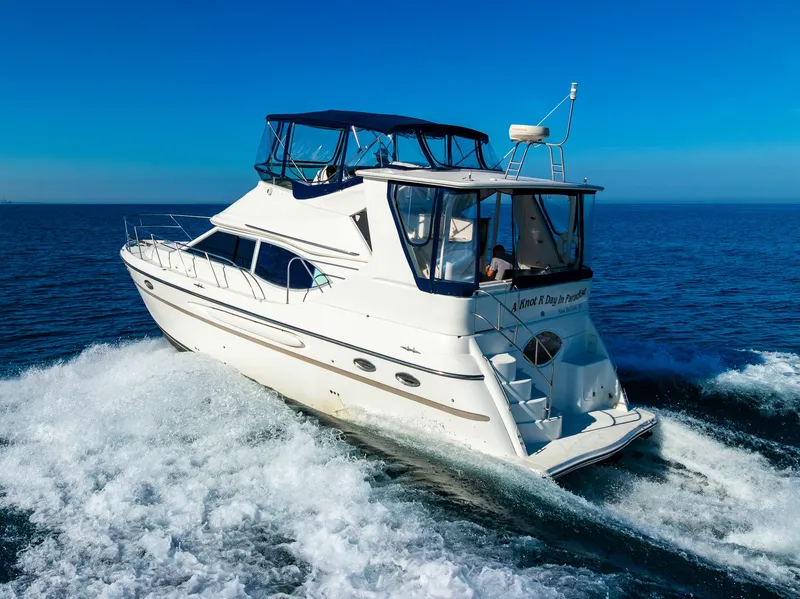 Slide: The Image of 1999 Maxum 4100 SCA Motor Yacht cruising on open sea under clear blue sky. - 12