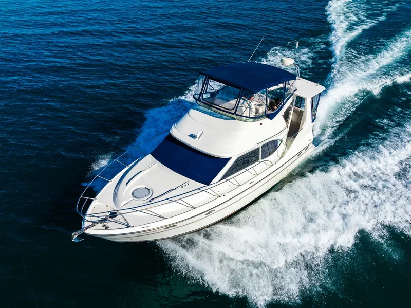 Slide: The Image of 1999 Maxum 4100 SCA Motor Yacht cruising on open water, aerial view. - 15