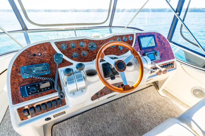 Slide: The Image of 1999 Maxum 4100 SCA Motor Yacht helm with wood accents and navigation equipment. - 17