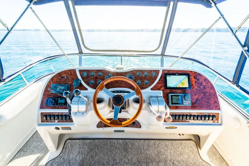 Slide: The Image of Cockpit of 1999 Maxum 4100 SCA Motor Yacht with wooden steering wheel and navigation controls. - 18