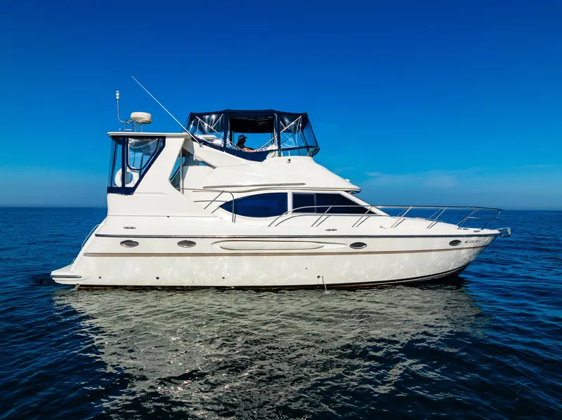Slide: The Image of 1999 Maxum 4100 SCA Motor Yacht on calm blue ocean under clear sky. - 2