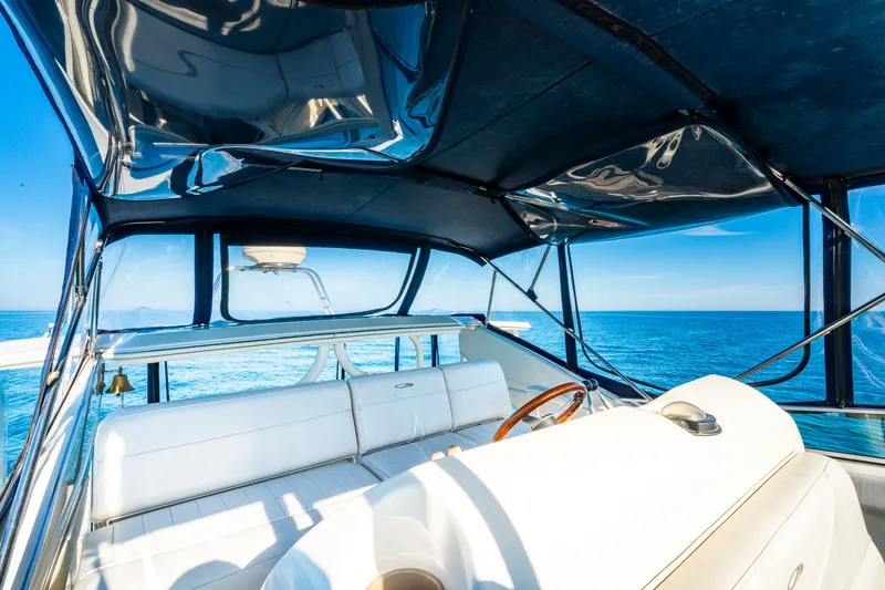 Slide: The Image of 1999 Maxum 4100 SCA Motor Yacht interior with ocean view, featuring white seating and steering wheel. - 21