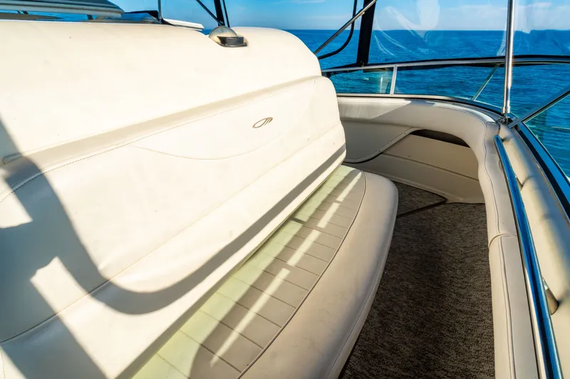 Slide: The Image of 1999 Maxum 4100 SCA Motor Yacht interior with white seating and ocean view. - 23