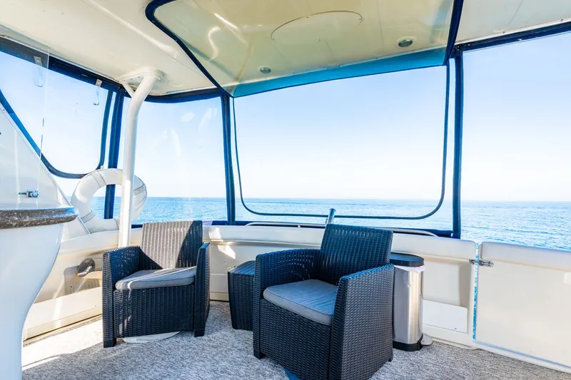 Slide: The Image of 1999 Maxum 4100 SCA Motor Yacht interior with ocean view and wicker chairs. - 27