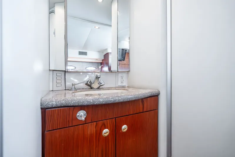 Slide: The Image of Bathroom vanity in 1999 Maxum 4100 SCA Motor Yacht with wood cabinetry and mirror. - 45