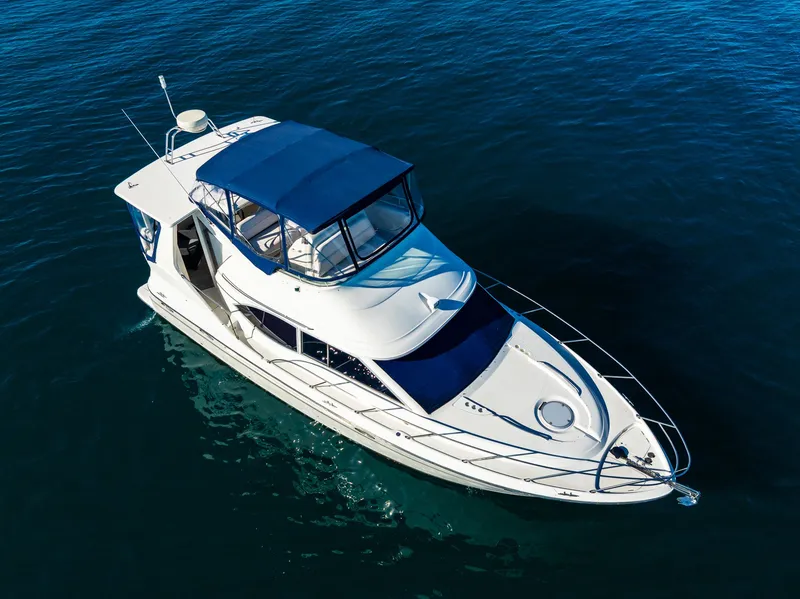 Slide: The Image of 1999 Maxum 4100 SCA Motor Yacht cruising on calm blue waters. - 6