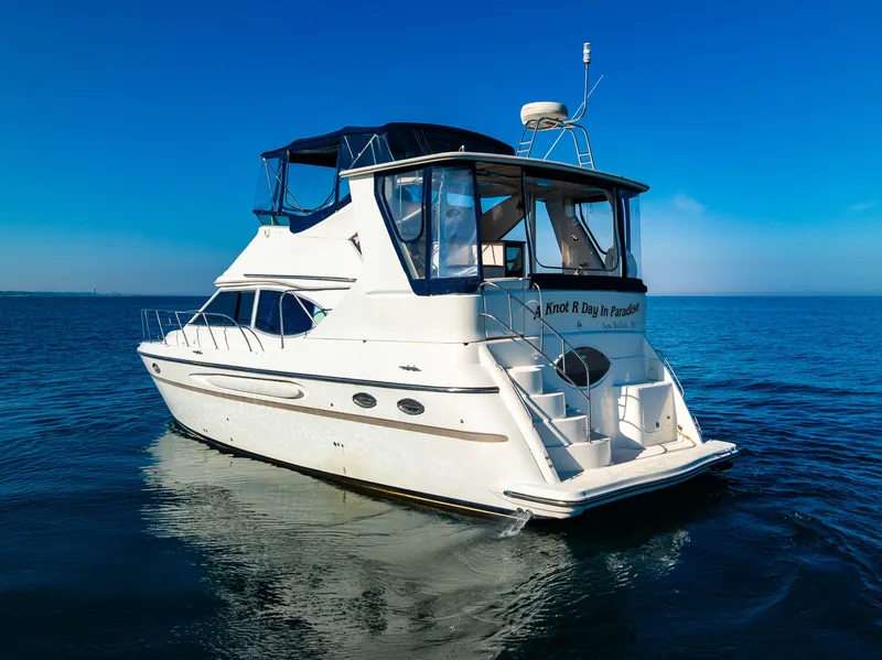 Slide: The Image of 1999 Maxum 4100 SCA Motor Yacht on calm blue water under clear sky. - 7