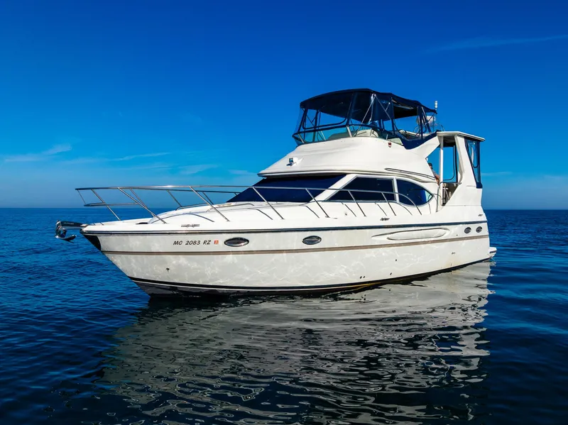 Slide: The Image of 1999 Maxum 4100 SCA Motor Yacht on calm blue water under clear sky. - 9